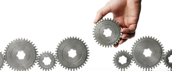 Integrated EDI represented by six silver gears, one being held by a hand